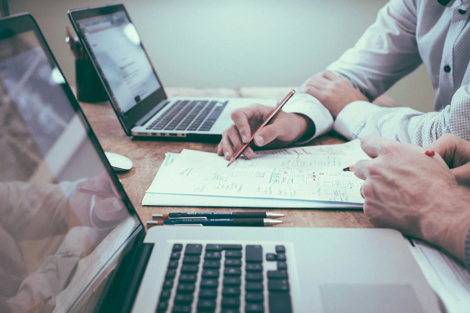 Two people reviewing paperwork at a laptop — founders setting up a company and its official business address.
