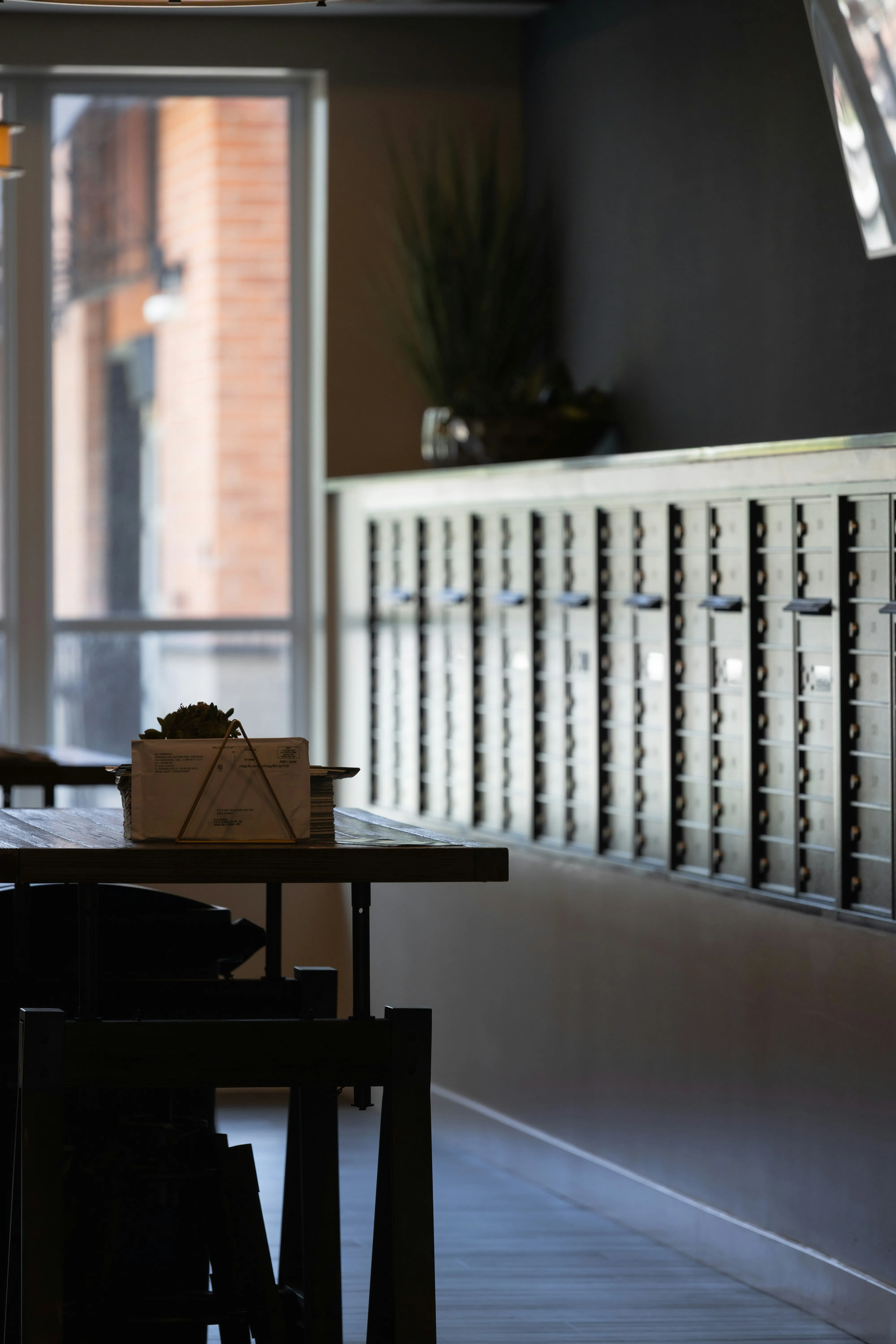 Mailboxes and a wrapped parcel in a virtual office mailroom — the mail-handling side of a Vienna business address.